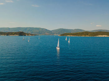 Sailboats in sea against sky