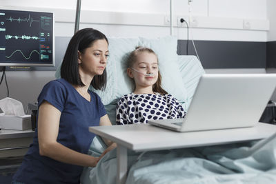 Mother and daughter talking on video call at hospital