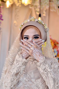 Portrait of young woman wearing hijab and looking at camera