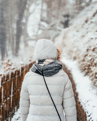 Rear view of woman walking on snow covered land