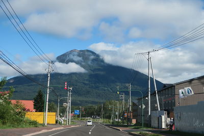 Road by mountain against sky