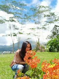 Woman standing by flowering plants