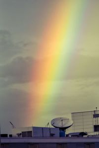 Low angle view of rainbow over buildings in city