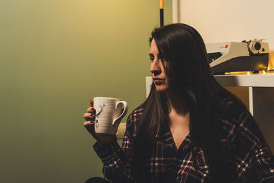 Portrait of young woman drinking coffee