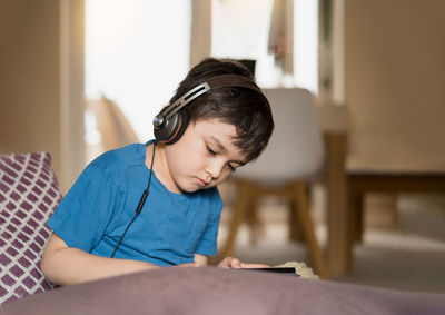 Boy sitting on mobile phone at home