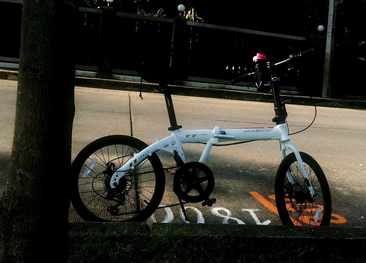 bicycle, transportation, mode of transport, land vehicle, stationary, parking, parked, street, night, illuminated, cycle, wheel, no people, outdoors, road, absence, street light, pole, built structure, car