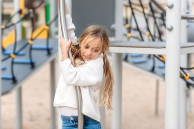 Girl hanging on metal in playground