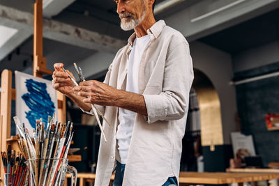 Midsection of man holding painting equipment