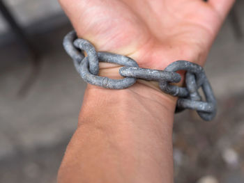 Cropped hand holding chain