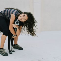 Young woman standing against wall