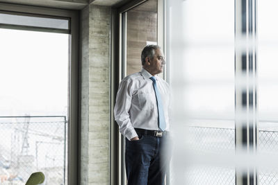 Senior manager in office standing at the window