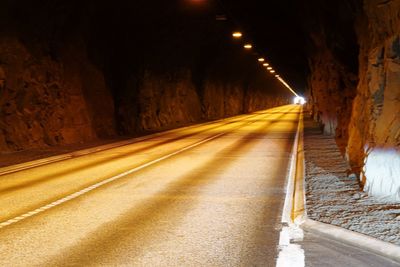 Illuminated tunnel at night