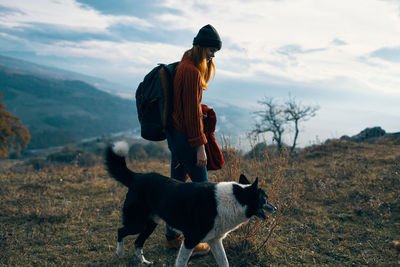 Dog standing on field against sky