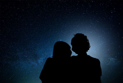 Silhouette couple against star field in sky at night