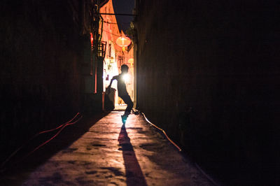 Boy dancing in alley at night