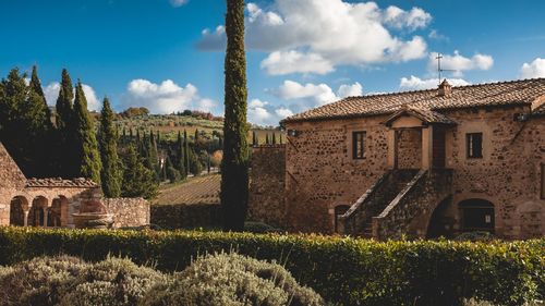 Panoramic view of small stone building in val d'orcia against sky