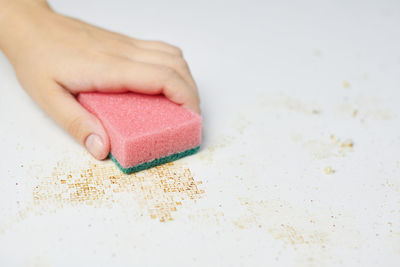 Close-up of hand on pink table