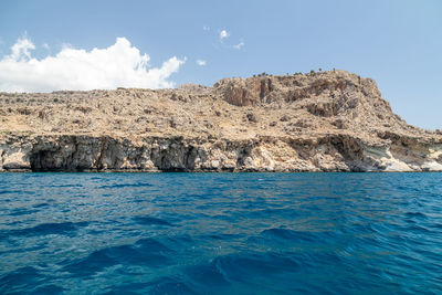 Scenic view of rock formation in sea against sky