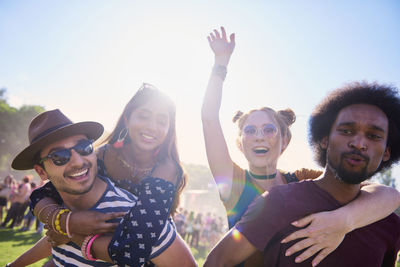 Portrait of smiling friends against sky