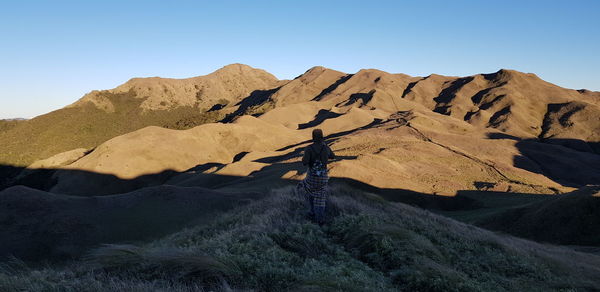 Scenic view of arid landscape against clear blue sky