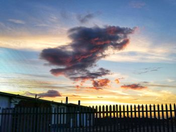 Silhouette fence against sky during sunset