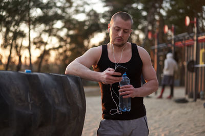 Full length of young man drinking outdoors