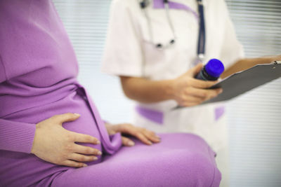 Midsection of doctor examining patient in hospital