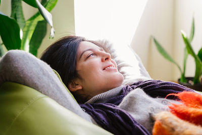 Woman relaxing on bean bag at home