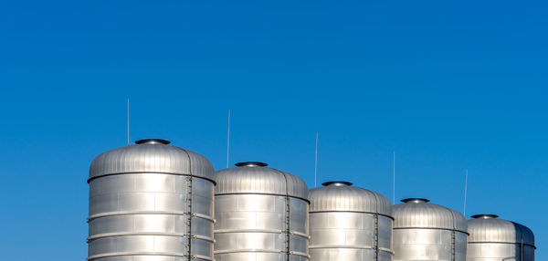 Low angle view of smoke stack against blue sky