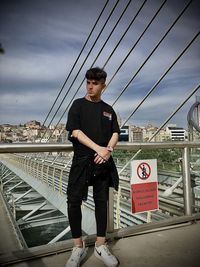 Full length of man standing by railing against sky