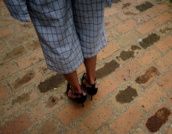 Low section of man standing on tiled floor