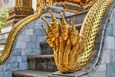 Close-up of statue on railing of staircase in temple