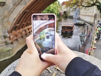 Midsection of person using mobile phone in city