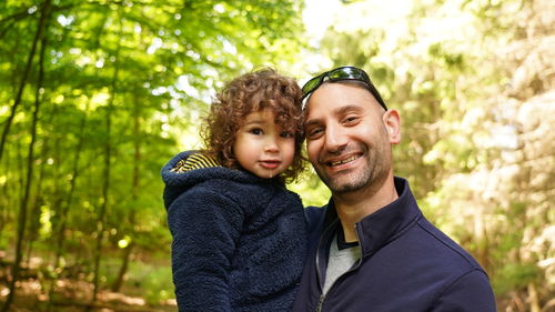 Father and daughter standing in forest