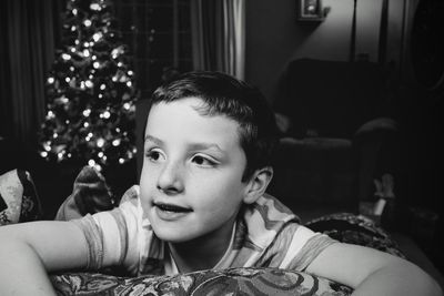 Boy by christmas tree at home