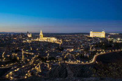 High angle view of city lit up at night