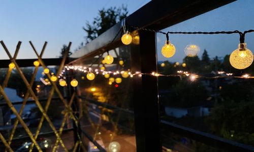 Illuminated lights hanging by building at night
