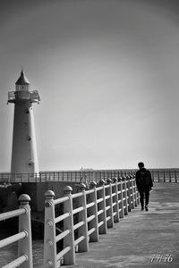 Man standing on lighthouse against clear sky