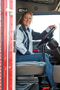 Portrait of smiling woman sitting in bus