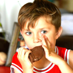 Close-up portrait of boy holding camera