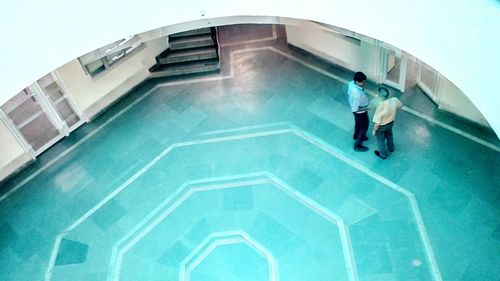 High angle view of man standing by swimming pool