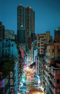 Illuminated buildings in city against clear sky