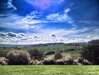 Scenic view of grassy field against cloudy sky