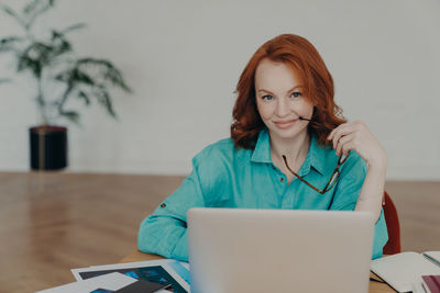 Portrait of smiling businesswoman using laptop at home