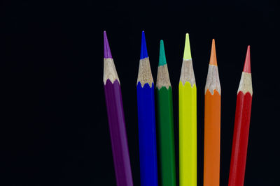Close-up of colored pencils against black background
