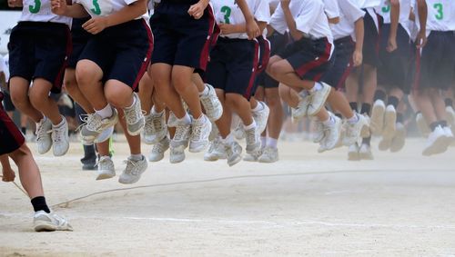 Low section of people jumping over a skipping rope