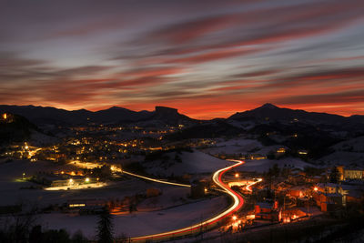 High angle view of illuminated cityscape against sky during sunset