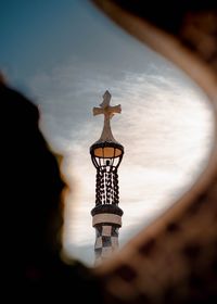 Illuminated lamp post by building against sky