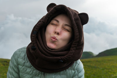 Portrait of young woman standing against sky