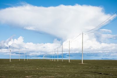 Electricity pylon on field against sky